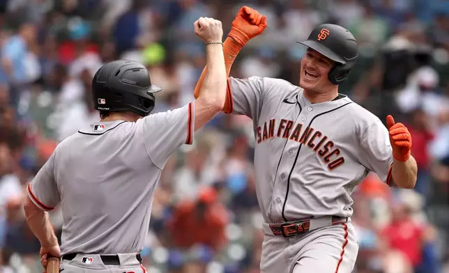 San Francisco Giants' Matt Chapman, right, celebrates with the Giants bat boy Carter Pierce after hitting a three-run home run, his second home run of the baseball game, in the sixth inning against the Chicago Cubs at Wrigley Field, Friday, June 5, 2026, in Chicago. (AP Photo/Geoff Stellfox)