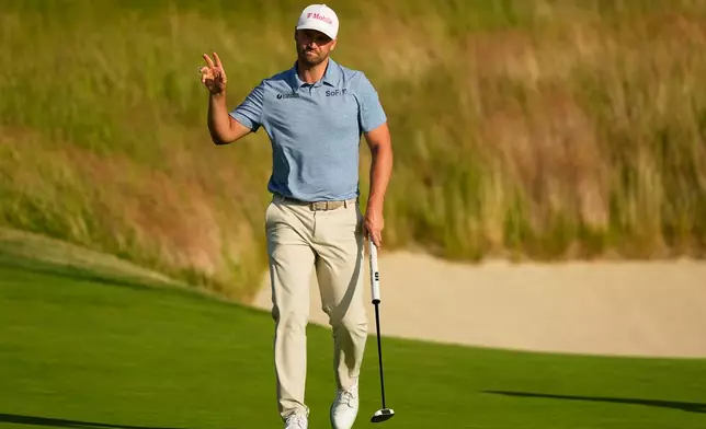 Wyndham Clark waves after his putt on the 18th hole during the first round of the U.S. Open golf tournament at Shinnecock Hills Golf Club in Southampton, N.Y., Thursday, June 18, 2026.(AP Photo/Gerald Herbert)
