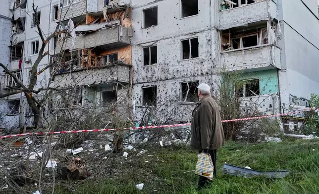 A resident looks at the site of a Russian missile strike that hit a residential building in Kyiv, Ukraine, Tuesday, June 2, 2026. (AP Photo/Efrem Lukatsky)