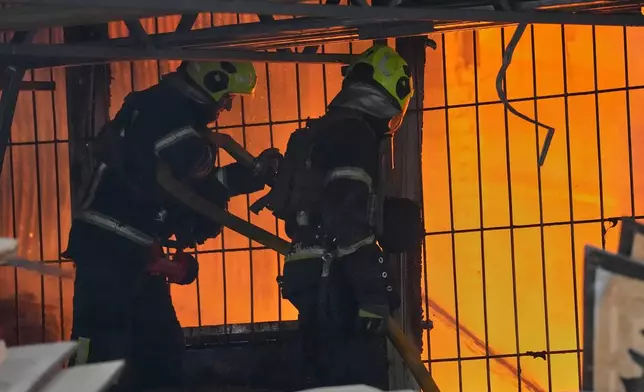 Firefighters work on the site of a burning building after a Russian missile attack in Kyiv, Ukraine, Tuesday, June 2, 2026. (AP Photo/Efrem Lukatsky)
