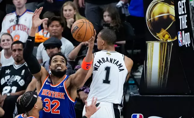 New York Knicks center Karl-Anthony Towns (32) rebounds over San Antonio Spurs forward Victor Wembanyama during the second half of Game 5 of the NBA Finals basketball series, Saturday, June 13, 2026, in San Antonio. (AP Photo/Ross D. Franklin)