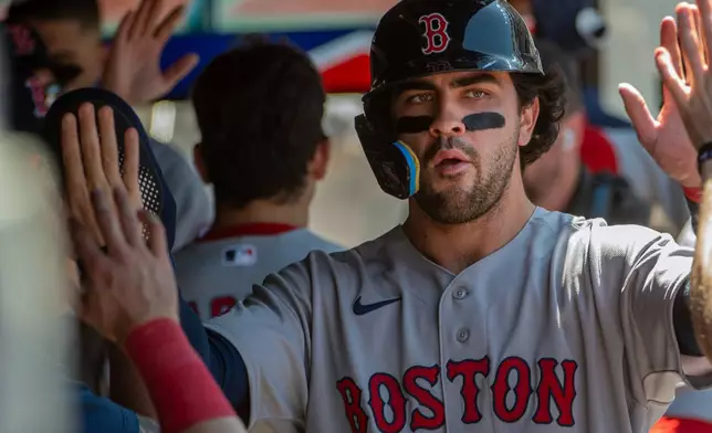 Boston Red Sox's Marcelo Mayer is congratulated after scoring on a sacrifice fly hit by Mickey Gasper during the fifth inning of a baseball game, Sunday, May 31, 2026, in Cleveland. (AP Photo/Phil Long)