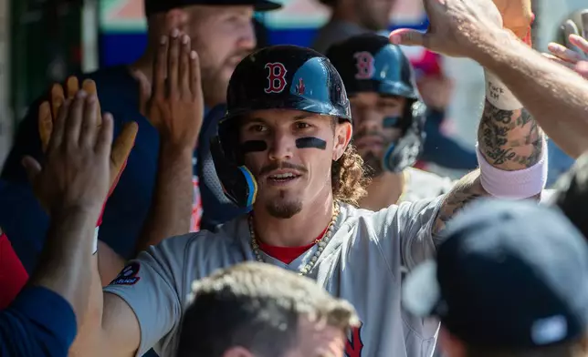 Boston Red Sox's Jarren Duran is greeted by teammates after scoring on an RBI single by Masataka Yoshida during the seventh inning of a baseball game against the Cleveland Guardians, Sunday, May 31, 2026, in Cleveland. (AP Photo/Phil Long)