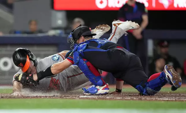 Baltimore Orioles' Pete Alonso (25) is tagged out by Toronto Blue Jays catcher Brandon Valenzuela (59) during eighth inning American League, MLB baseball action in Toronto on Friday, June 5, 2026. (Nathan Denette/The Canadian Press via AP)