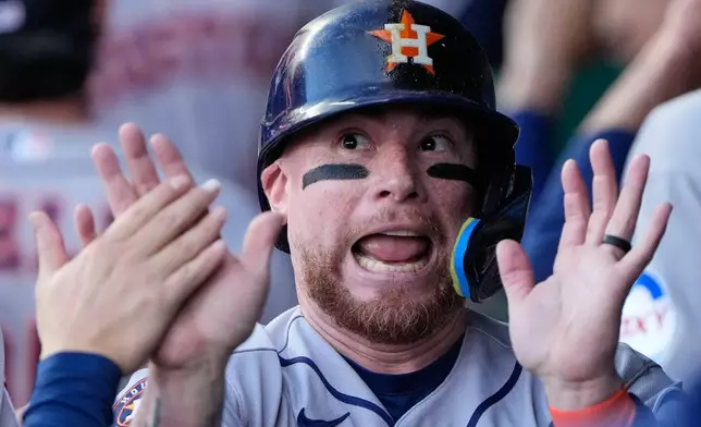 Houston Astros' Christian Vazquez celebrates in the dugout after scoring on a grand slam hit by Yordan Alvarez during the first inning of a baseball game against the Kansas City Royals, Friday, June 12, 2026, in Kansas City, Mo. (AP Photo/Charlie Riedel)