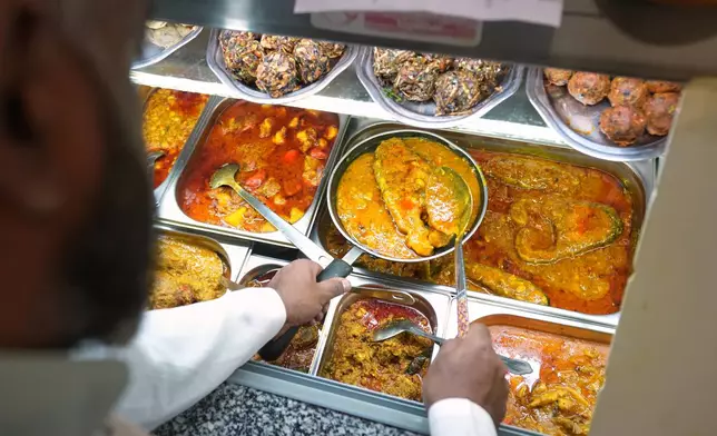 Chef Mohammed Shanoor Ali prepares food at a Bangladeshi restaurant in London, Thursday, June 18, 2026. (AP Photo/Kin Cheung)