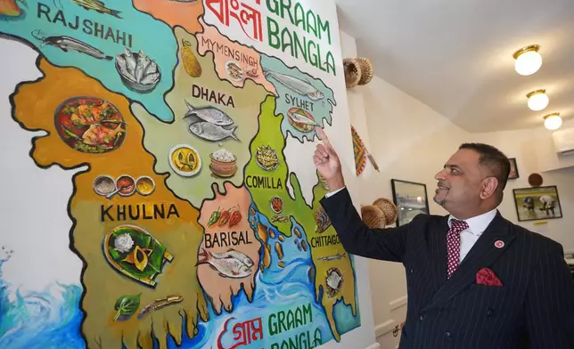 Oli Khan, the senior vice president of the Bangladesh Caterers Association UK, shows a map at a Bangladeshi restaurant in London, Thursday, June 18, 2026. (AP Photo/Kin Cheung)