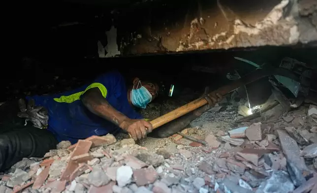 Franklin Rodriguez searches for missing relatives in the rubble of his apartment building, which collapsed in the back-to-back earthquakes that struck La Guaira, Venezuela, Monday, June 29, 2026. (AP Photo/Fernando Vergara)