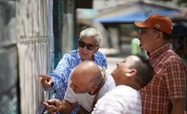 Voters check electoral lists at a polling station in Puerto Colombia, Colombia, Sunday, May 31, 2026. (AP Photo/Ivan Valencia)