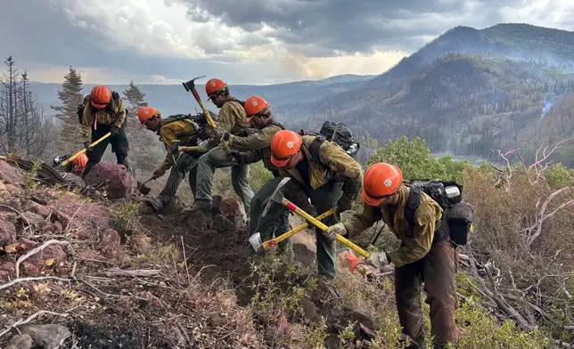 This undated image provided by the U.S. Forest Service Friday, June 26, 2026, shows firefighters responding to the Cottonwood Fire on Wednesday, June 24, 2026, above Birch Lake, near Beaver, Utah. (Mike McMillan/U.S. Forest Service via AP)