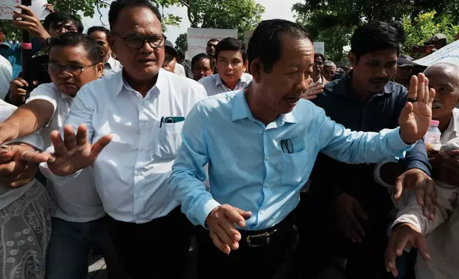 Rong Chhun, a prominent Cambodian opposition politician, right, leaves his Supreme Court hearing in Phnom Penh, Cambodia, Monday, June 15, 2026. (AP Photo/Heng Sinith)