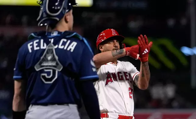 Los Angeles Angels' Jose Siri, right, gestures as he scores after hitting a two-run home run as Tampa Bay Rays catcher Hunter Feduccia looks on during the seventh inning of a baseball game Saturday, June 13, 2026, in Anaheim, Calif. (AP Photo/Mark J. Terrill)