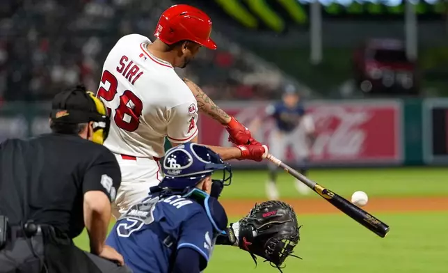Los Angeles Angels' Jose Siri, center, hits a two-run home run as Tampa Bay Rays catcher Hunter Feduccia, right, and home plate umpire Dave Rackley watch during the seventh inning of a baseball game Saturday, June 13, 2026, in Anaheim, Calif. (AP Photo/Mark J. Terrill)
