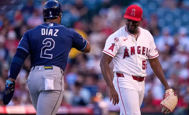 Los Angeles Angels starting pitcher José Soriano, right, and Tampa Bay Rays' Yandy Díaz greet each other after the top of the first inning of a baseball game Saturday, June 13, 2026, in Anaheim, Calif. (AP Photo/Mark J. Terrill)