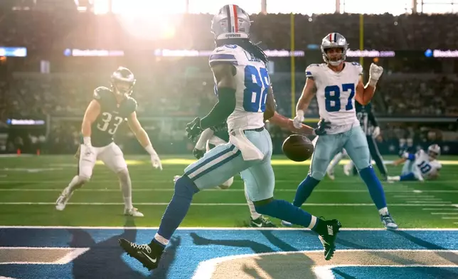 FILE - Dallas Cowboys wide receiver CeeDee Lamb runs past a pass thrown into the end zone by quarterback Cooper Rush as Philadelphia Eagles' Cooper DeJean (33) and Jake Ferguson (87) look on in the first half of an NFL football game in Arlington, Texas, Nov. 10, 2024. (AP Photo/Jeffrey McWhorter, File)
