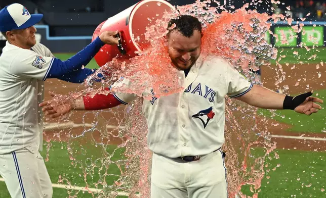Toronto Blue Jays outfielder Myles Straw, left, douses teammate catcher Alejandro Kirk with a sports drink to celebrate their team's victory over the Houston Astros in a baseball game in Toronto, Monday, June 22, 2026. (Jon Blacker/The Canadian Press via AP)