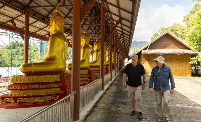 Researchers Andrew Snow, left, and Martyn Fryer visit the Buddhist temple of Wat Tha Khanun, which preserves a section of the infamous World War II "Death Railway," in Thong Pha Phum, Thailand, on Saturday, May 30, 2026. (AP Photo/Anton L. Delgado)