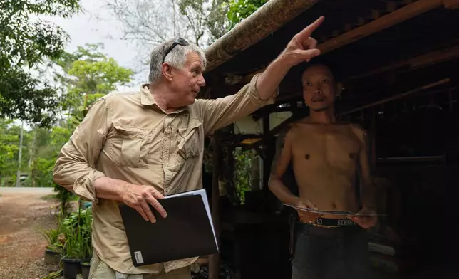 Martyn Fryer, an independent researcher, asks a local landowner for permission to survey a part of the infamous World War II "Death Railway," in Sangkhlaburi, Thailand on Friday, May 29, 2026. (AP Photo/Anton L. Delgado)