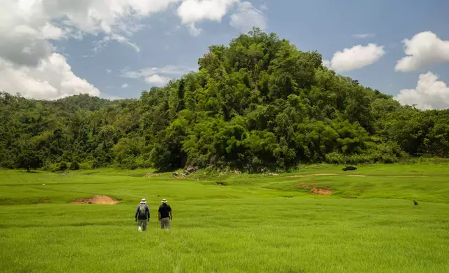 Researchers walk into the empty reservoir where Nithe Station, a depot on World War II's infamous "Death Railway" resurfaced after the reservoir was drained in Sangkhlaburi, Thailand on Saturday, May 30, 2026. (AP Photo/Anton L. Delgado)