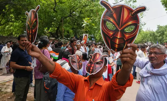 Supporters of the Cockroach Janta Party wear and display masks during a protest demonstration in New Delhi, India, Saturday, June 6, 2026. (AP Photo/Manish Swarup)