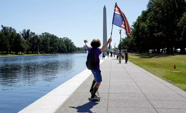 A man with an upside-down U.S. flag is seen near the Reflecting Pool, Wednesday, June 24, 2026, in Washington. (AP Photo/Rahmat Gul)