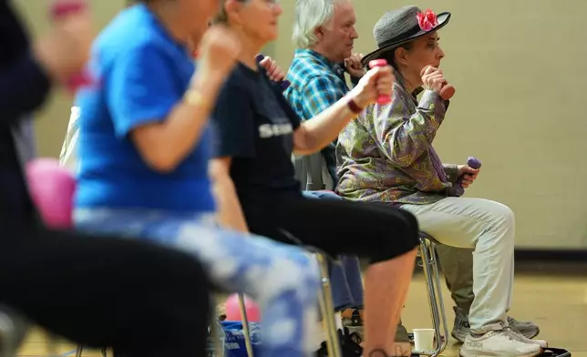 Eileen Weintraub uses light weights during a class for older adults led by Bengie Santos at the Dale Turner Family YMCA, April 30, 2026, in Shoreline, Wash. (AP Photo/Lindsey Wasson)