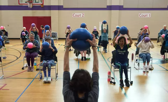 Instructor Bengie Santos, 72, foreground center, leads a class for older adults at the Dale Turner Family YMCA, April 30, 2026, in Shoreline, Wash. (AP Photo/Lindsey Wasson)