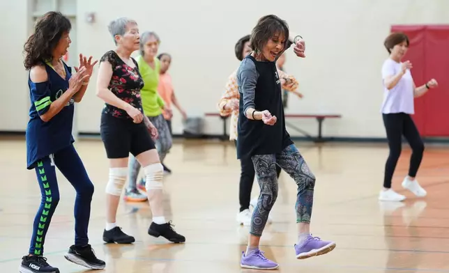 Instructor Bengie Santos, 72, leads a class for older adults, including Pilar Madayag, left, at the Dale Turner Family YMCA, April 30, 2026, in Shoreline, Wash. (AP Photo/Lindsey Wasson)
