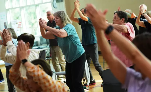 Participants do arm exercises during an exercise class for older adults led by instructor Bengie Santos, 72, at the Dale Turner Family YMCA, April 30, 2026, in Shoreline, Wash. (AP Photo/Lindsey Wasson)