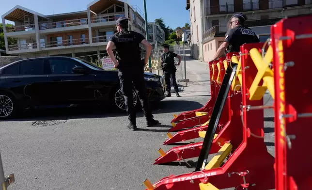France Police officers control cars at a check point ahead of the G7 summit in Evian-les-Bains, France, Monday, June 15, 2026. (AP Photo/Christophe Ena)