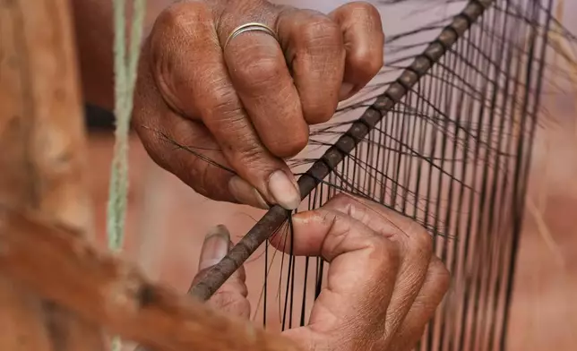 An artisan weaves horsehair sieves, a mesh known as a “cedazo,” in Guangopolo, Ecuador, Wednesday, June 3, 2026. (AP Photo/Dolores Ochoa)