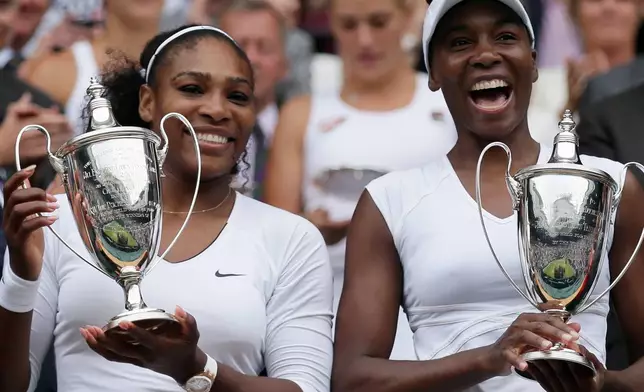 FILE -Serena Williams, left, and Venus Williams of the U.S hold their trophies after winning the women's doubles final against Yaroslava Shvedova of Kazahkstan and Timea Babos of Hungary on day thirteen of the Wimbledon Tennis Championships in London, July 9, 2016. (AP Photo/Tim Ireland, File)