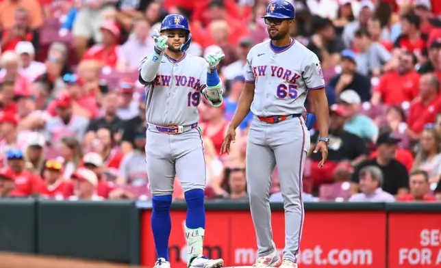 New York Mets' Bo Bichette, left, celebrates after hitting an RBI single during the third inning of a baseball game against the Cincinnati Reds in Cincinnati, Tuesday, June 16, 2026. (AP Photo/Ben Jackson)