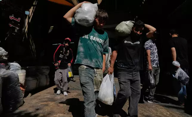 People carry packages at Tehran's historic Grand Bazaar, Iran, Monday, June 1, 2026. (AP Photo/Vahid Salemi)