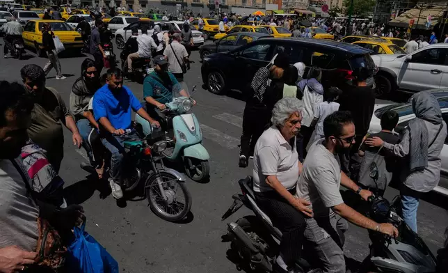 Pedestrians and vehicles cross an intersection around Tehran's historic Grand Bazaar, Iran, Monday, June 1, 2026. (AP Photo/Vahid Salemi)
