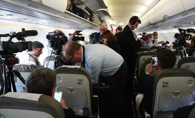 Journalists attend into the papal flight after takeoff was delayed at Los Rodeos International Airport, at the Canary Islands, Spain, Friday, June 12, 2026. (AP Photo/Alessandra Tarantino)