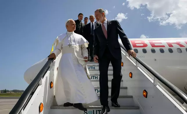 In this handout photo provided by Vatican Media, Pope Leo XIV is accompanied by King Felipe VI of Spain as he deplanes after a technical problem at Tenerife Norte-Los Rodeos International Airport in Tenerife, Spain, Friday, June 12, 2026. (Vatican Media via AP)
