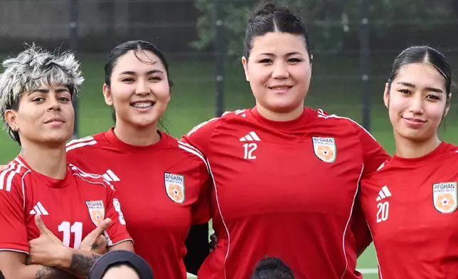 Afghan women's player Fatima Yousufi, second right, stands with teammates in a team photo following a training session in Auckland, New Zealand, Tuesday, June 2, 2026. (Andrew Cornaga/Photosport via AP)