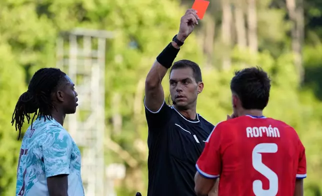 Referee Luca Zufferli shows red cards to Portugal's Rafael Leao, left, and Chile's Ivan Roman during an international friendly soccer match between Portugal and Chile in Oeiras, outside Lisbon, Saturday, June 6, 2026. (AP Photo/Armando Franca)
