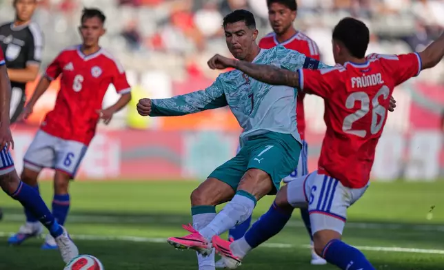 Portugal's Cristiano Ronaldo, center, and Chile's Felipe Faundez challenge for the ball during an international friendly soccer match between Portugal and Chile in Oeiras, outside Lisbon, Saturday, June 6, 2026. (AP Photo/Armando Franca)