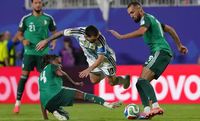 Argentina's Lionel Messi (10) battles for the ball with Algeria's Nabil Bentaleb (19) and Algeria's Hicham Boudaoui (14) during the World Cup Group J soccer match between Argentina and Algeria in Kansas City, Mo., Tuesday, June 16, 2026. (AP Photo/Ed Zurga)