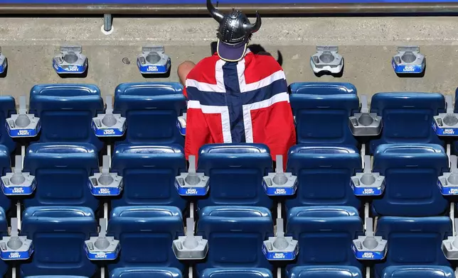 A Norway fan dons a viking helmet nd flag waiting for the start of the World Cup Group I soccer match between Iraq and Norway in Foxborough, Mass., near Boston, Tuesday, June 16, 2026. (AP Photo/Mark Stockwell)