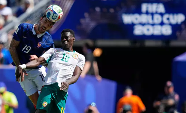 France's Theo Hernandez, left, jumps for the ball with Senegal's Ismaila Sarr during the World Cup Group I soccer match between France and Senegal in East Rutherford, N.J., near New York, Tuesday, June 16, 2026. (AP Photo/Yuki Iwamura)