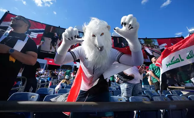 An Iraq fan dressed in a lion costume poses for photos prior to the World Cup Group I soccer match between Iraq and Norway in Foxborough, Mass., near Boston, Tuesday, June 16, 2026. (AP Photo/Martin Meissner)