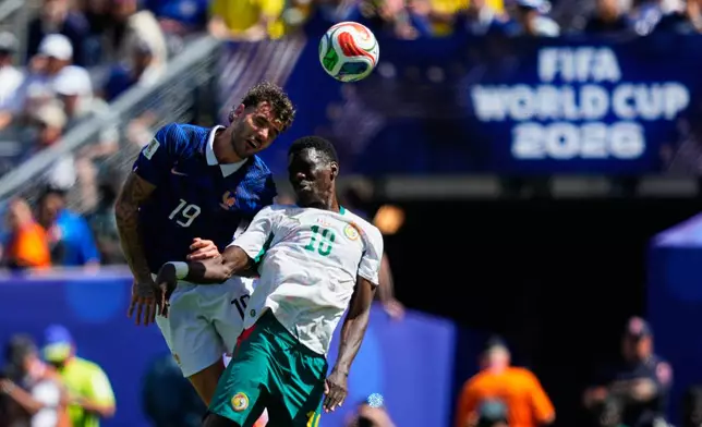 France's Theo Hernandez, left, jumps for the ball with Senegal's Ismaila Sarr during the World Cup Group I soccer match between France and Senegal in East Rutherford, N.J., near New York, Tuesday, June 16, 2026. (AP Photo/Yuki Iwamura)