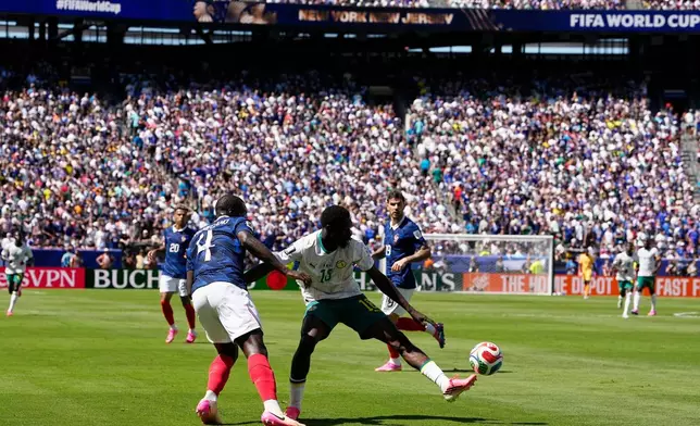 France's Dayot Upamecano, left, passes the ball as Senegal's Ismaila Sarr tries to stop him during the World Cup Group I soccer match between France and Senegal in East Rutherford, N.J., near New York, Tuesday, June 16, 2026. (AP Photo/Frank Franklin II)