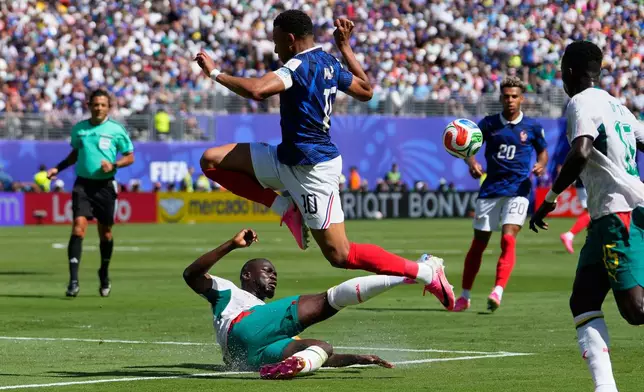 Senegal's Kalidou Koulibaly, on the ground, steals the ball from France's Kylian Mbappe during the World Cup Group I soccer match between France and Senegal in East Rutherford, N.J., near New York, Tuesday, June 16, 2026. (AP Photo/Yuki Iwamura)