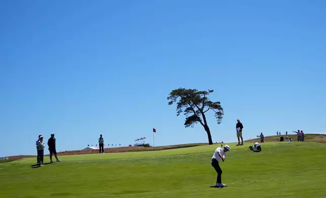 T.K. Kim chips to the green on the 14th hole during a practice round for the U.S. Open golf tournament at Shinnecock Hills Golf Club in Southampton, N.Y., Tuesday, June 16, 2026.(AP Photo/Gerald Herbert)