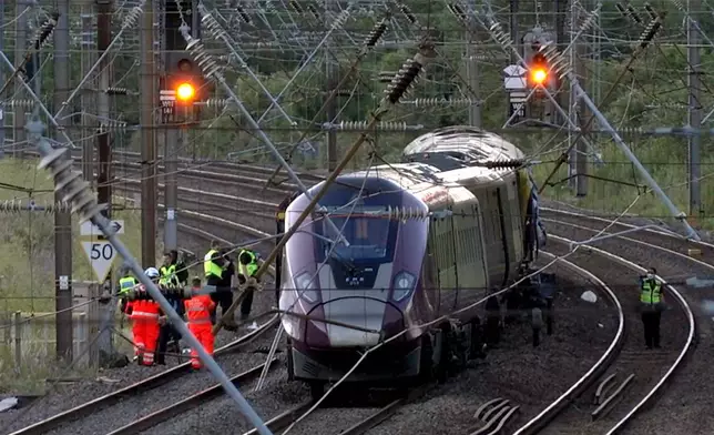Emergency personnel work on a train on the tracks outside Bedford, England, after a train from Corby to London St. Pancras and another from Nottingham to London St. Pancras, collided on Friday June 19, 2026. (Jamie Lashmar/PA via AP)