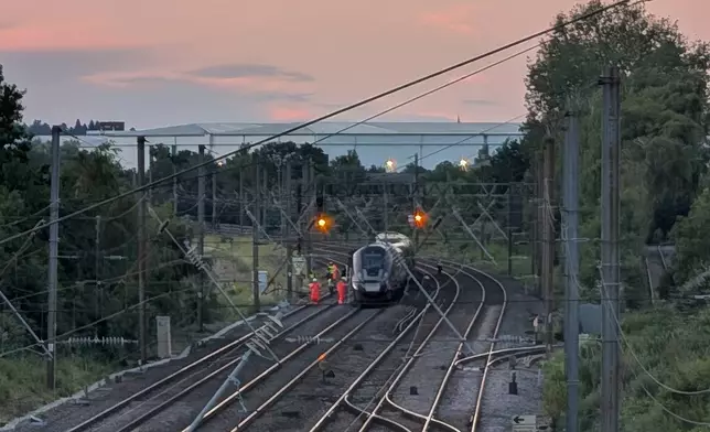 Emergency personnel work on a train on the tracks outside Bedford, England, after a train from Corby to London St. Pancras and another from Nottingham to London St. Pancras, collided on Friday June 19, 2026. (Jamie Lashmar/PA via AP)